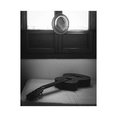 Chapeau, guitare sur un lit